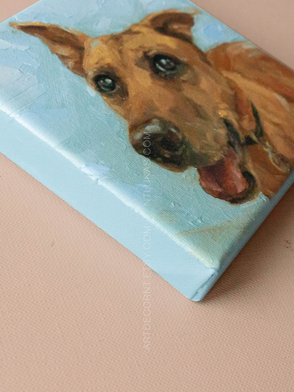 Canvas painting of a dog's face on a light blue background