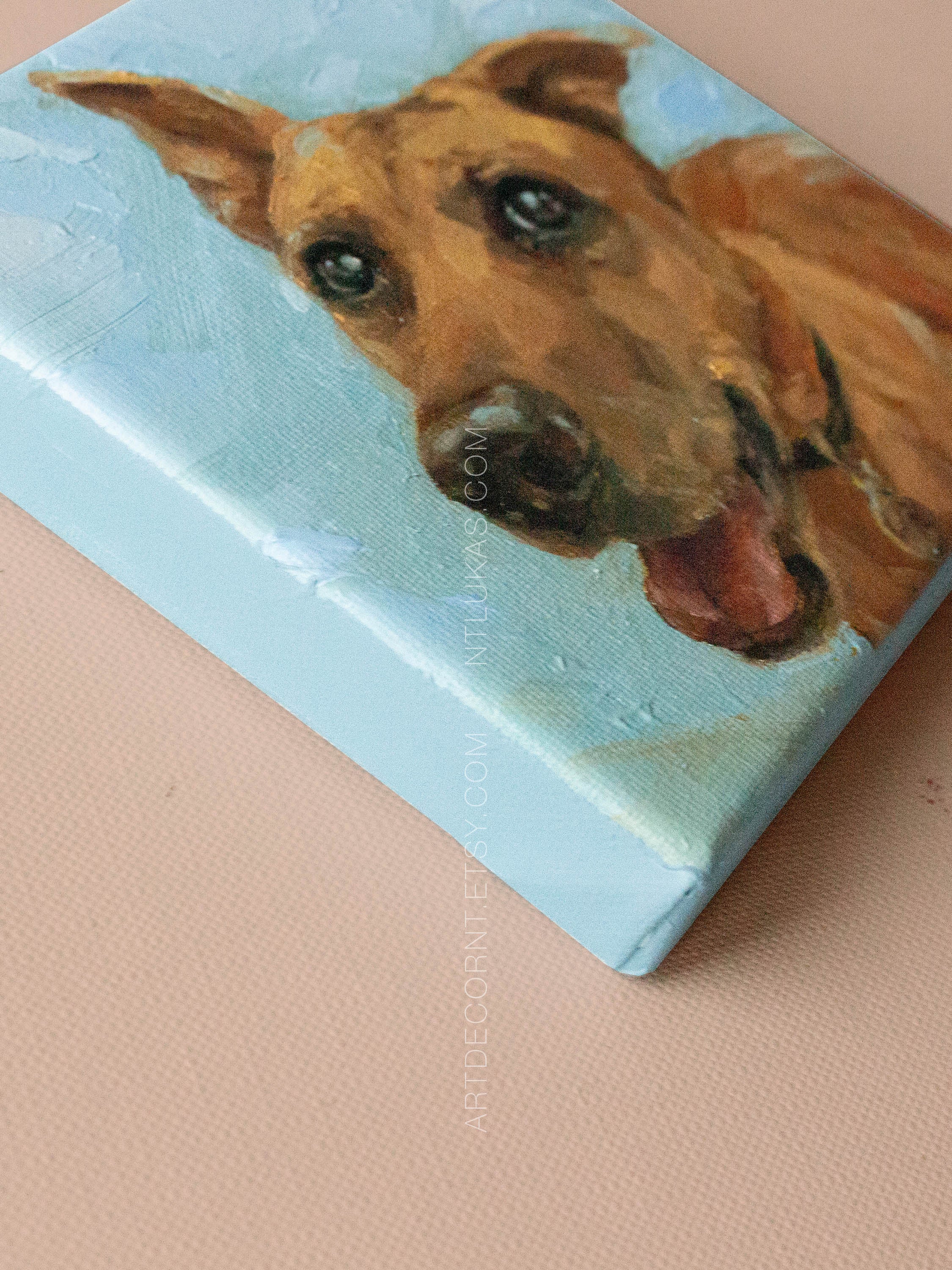Canvas painting of a dog's face on a light blue background